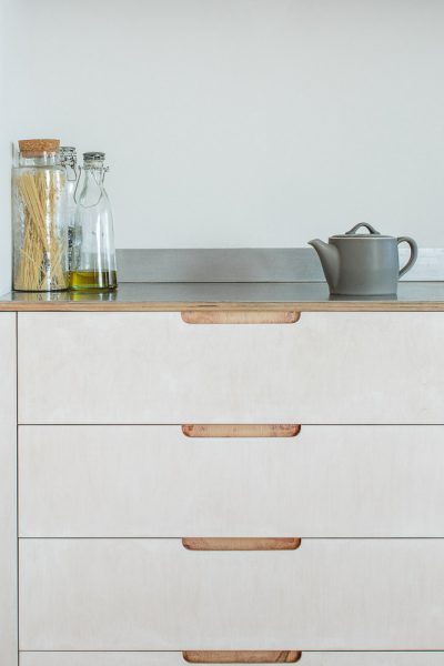 Close up of plywood drawer cabinet with brushed stainless steel worktop