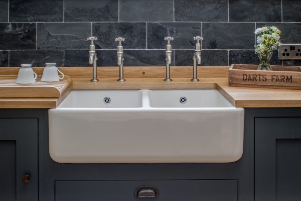 Belfast farmhouse sink with double bibcock taps and slate wall tiles