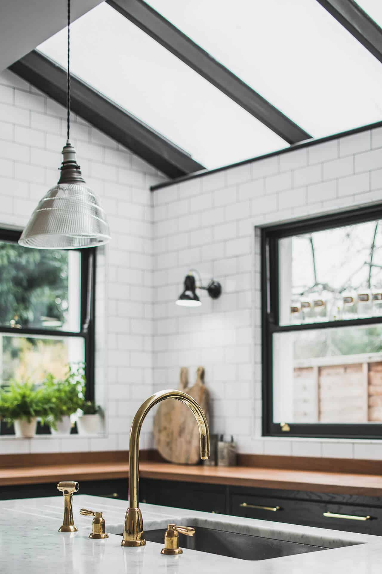 Dark Green Shaker kitchen with skylights, polished brass Perrin & Rowe tap on Carrera Marble Island